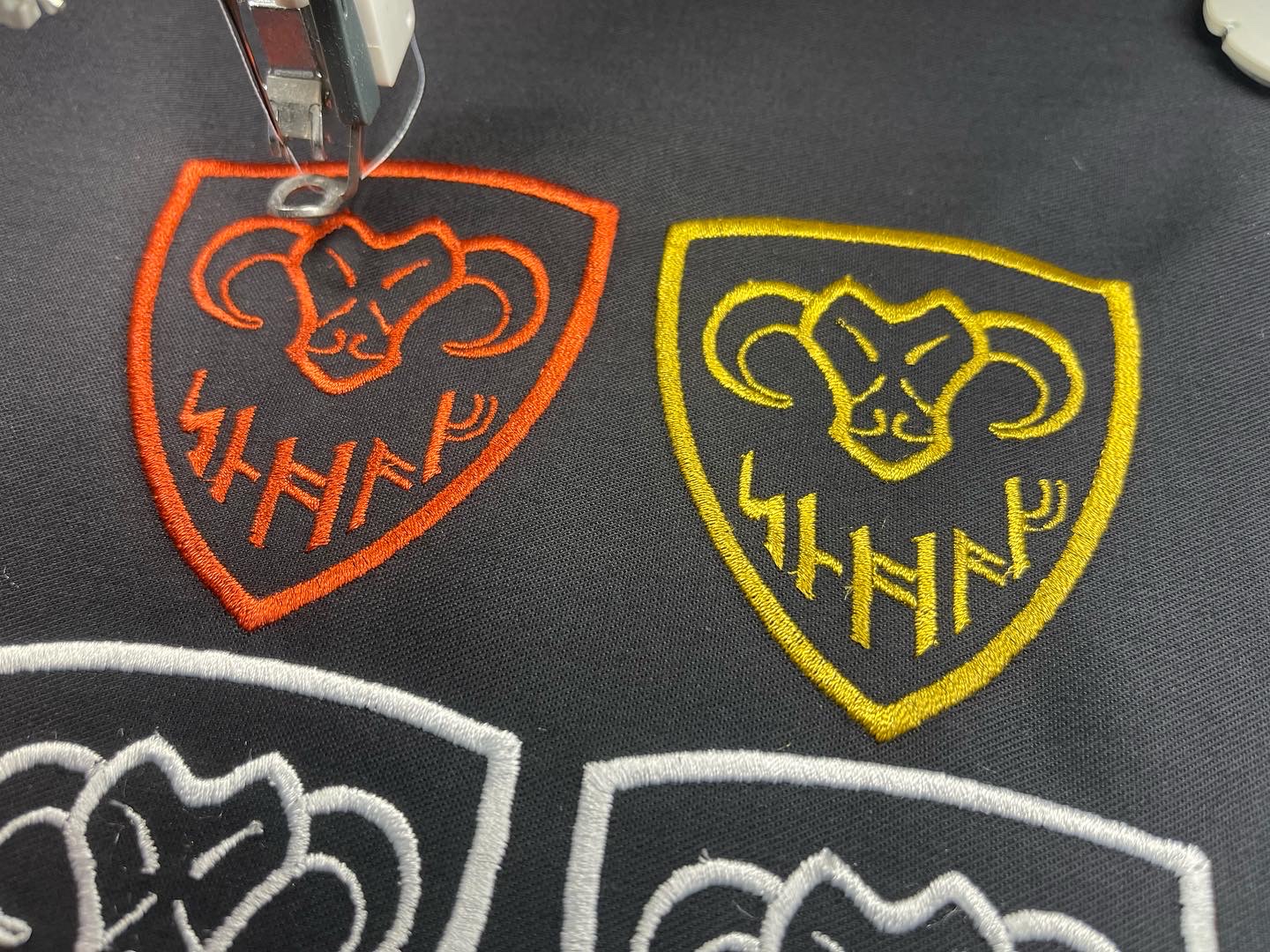 Gestickte Schaf-Patches in mehreren Farbvarianten auf schwarzem Stoff