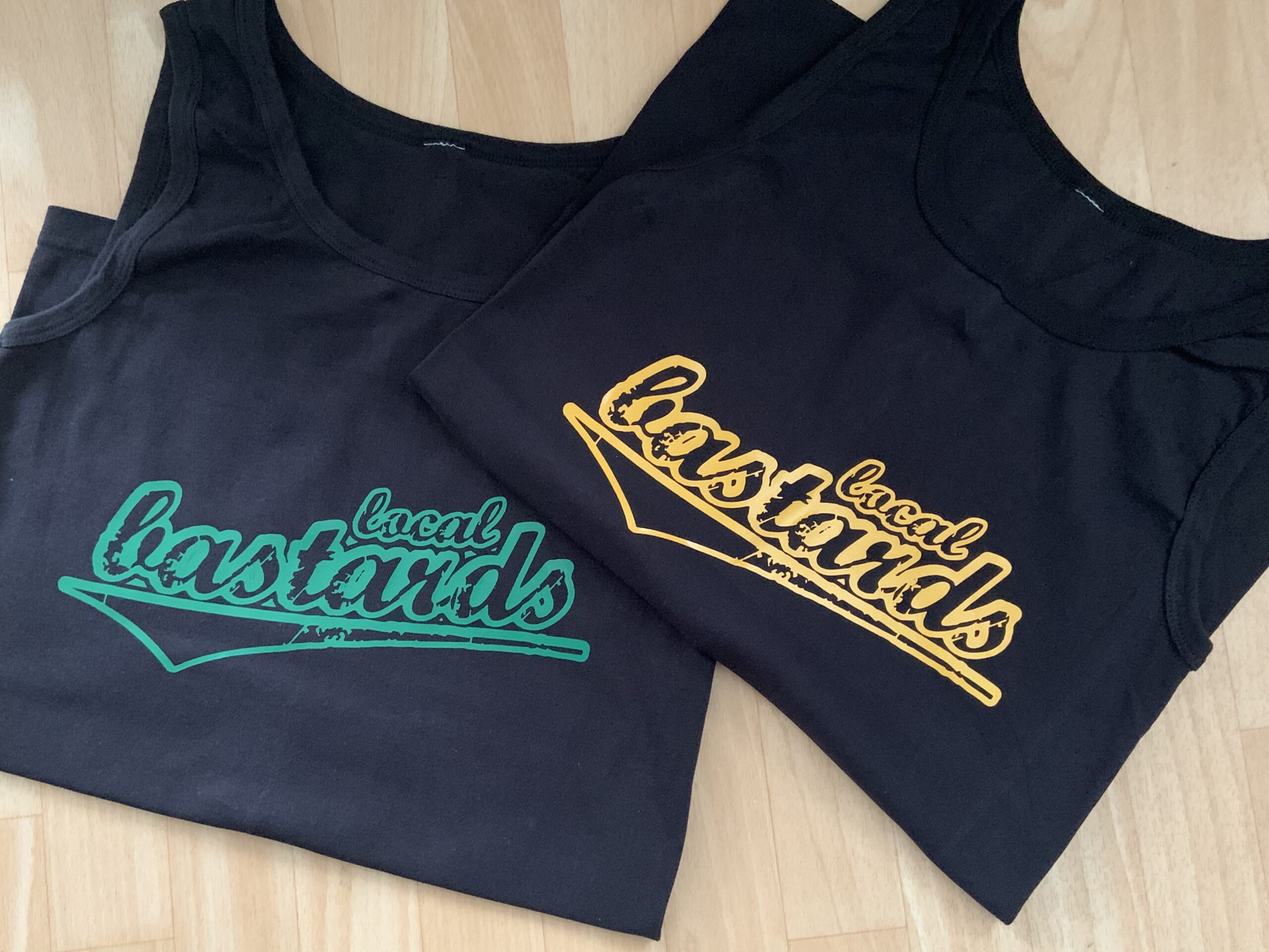Dunkle Tanktops mit farbigem Band-Fanclub-Schriftzug als Textildruck-Probedruck